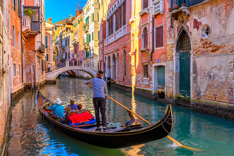 Narrow canal with gondola and bridge in Venice, Italy. Architecture and landmark of Venice. Cozy cityscape of Venice. Narrow canal with gondola and bridge in Venice, Italy. Architecture and landmark of Venice. Cozy cityscape of Venice.